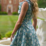 Woman wearing blue floral dress in front of fountain