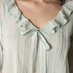 Close up of a woman wearing a green blouse