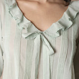 Close up of a woman wearing a green blouse