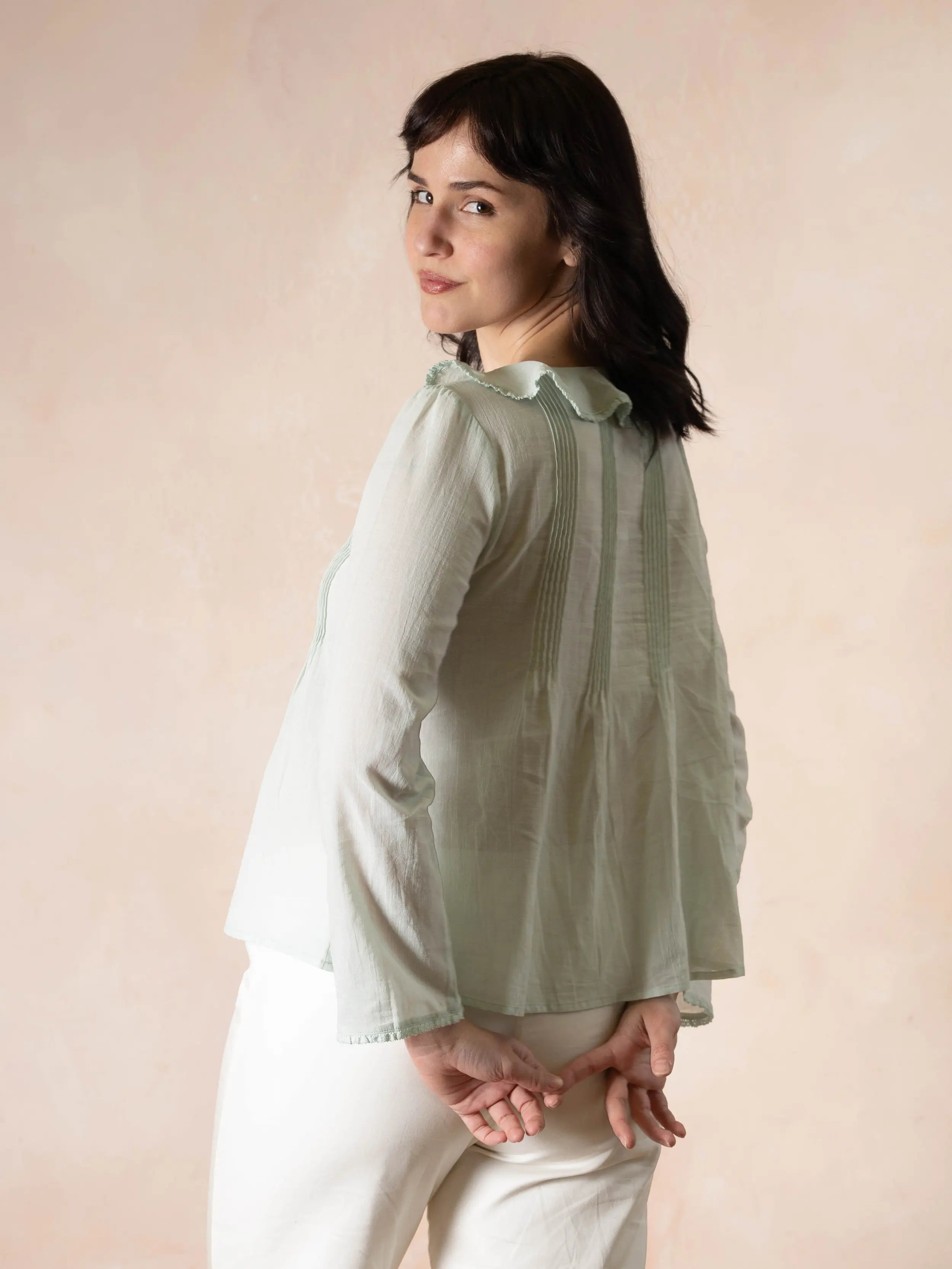 Model wearing mint colored long sleeve top