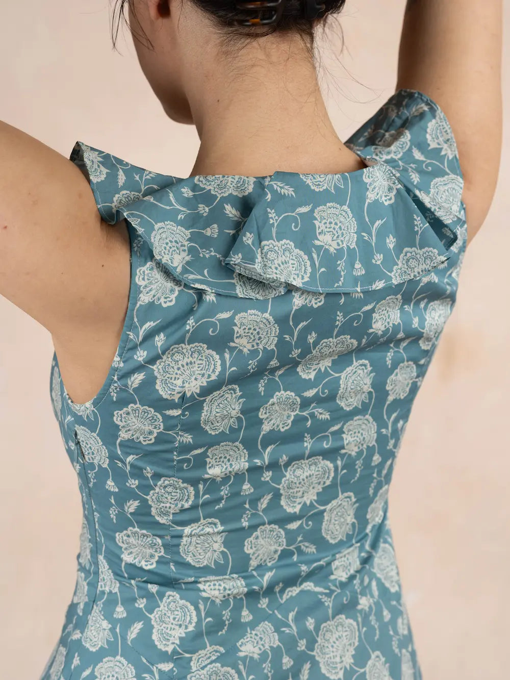Blue floral dress worn by a person on a beige background