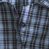 Close-up of a blue and black plaid shirt with a button.