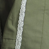 Close-up of green fabric with white lace trim