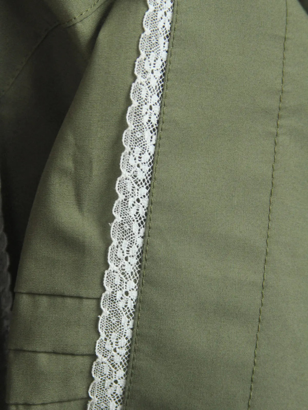 Close-up of green fabric with white lace trim