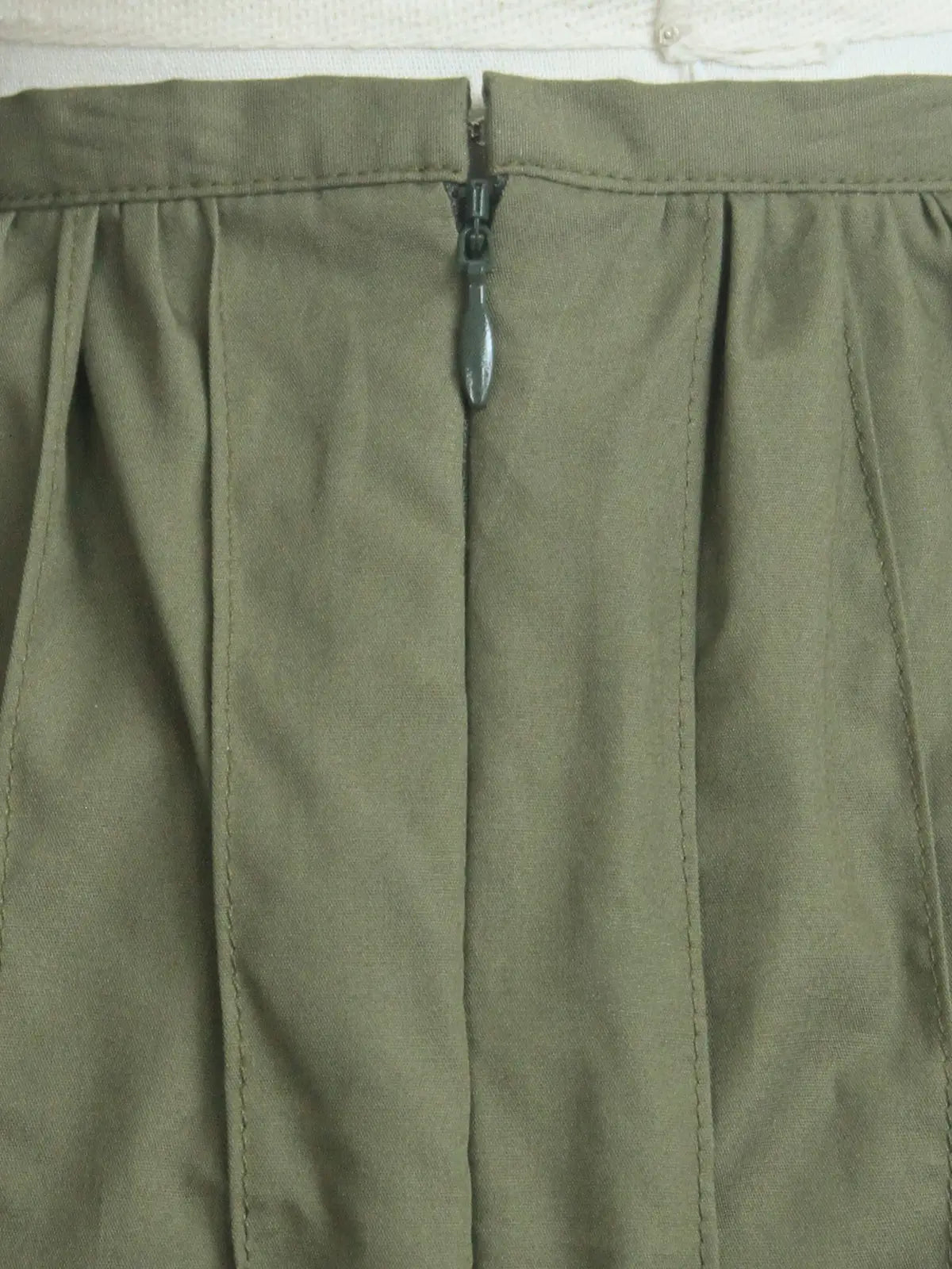 Close-up of green pants with a zipper on a white background