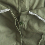 Close-up of a green shirt with lace trim on the collar.