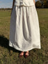 Person wearing a white skirt standing in a grassy field
