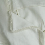 Close-up of a light-colored fabric with lace trim