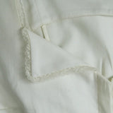 Close-up of a light-colored fabric with lace trim