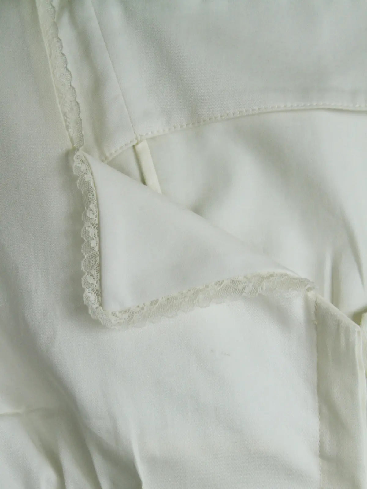 Close-up of a light-colored fabric with lace trim